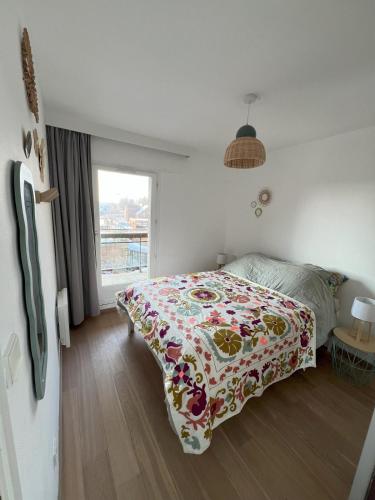 - une chambre avec un lit doté d'une couverture fleurie dans l'établissement L'Ancre Douce Sea View, à Bray-Dunes