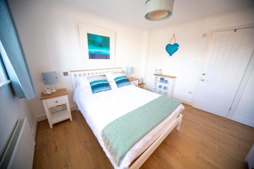 ein Schlafzimmer mit einem weißen Bett mit blauen Kissen in der Unterkunft Trethvor House FREE PARKING, Ensuite Double Quiet residential area in Padstow
