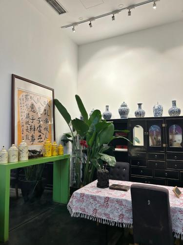 a room with a green table and vases at Hotel Cote Cour Deductive Beijing - Quadrangle close to Tiananmen Square & Forbidden City & Nanluoguxiang, Walk to Wangfujing, English speaking, Free WiFi, Free Laundry, Free Wonton & Noodles with Tour ticket service, Free selfies with ancient costume in Beijing