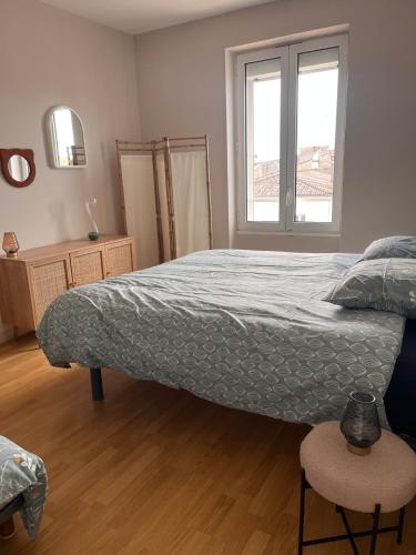 une chambre avec un grand lit et une fenêtre dans l'établissement Evasion Rêvée! Proche gare et clim, à Marmande