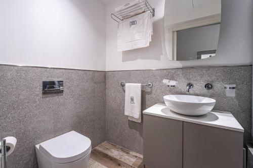 a bathroom with a sink and a toilet at Old Theatre Suites - Vulcano in Valletta