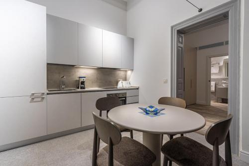 a kitchen with a table and chairs in a room at Old Theatre Suites - Vulcano in Valletta