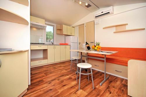 a kitchen with a counter and a table with fruits on it at Orsera Camping Resort by Valamar in Vrsar