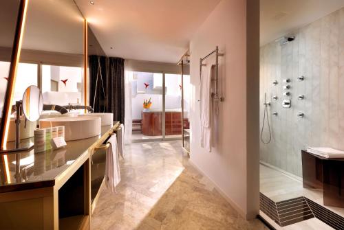 a bathroom with a tub and a sink and a shower at Ushuaïa Ibiza Beach Hotel - Adults Only - Club Entrance Included in Playa d'en Bossa