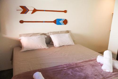 - une chambre avec un lit et 2 battes de base-ball sur le mur dans l'établissement Euodoo Suíte, à São Miguel dos Milagres