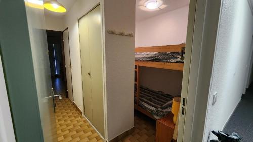 un couloir menant à une chambre avec des lits superposés dans l'établissement Sol-y-Days Lagune 2, studio Port Camargue Sud accès direct aux plages, au Grau-du-Roi