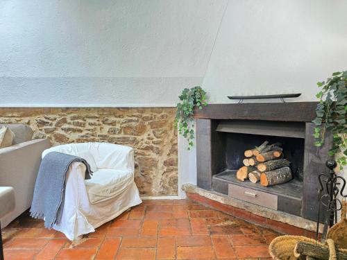 Una sala de estar con chimenea de piedra y un sofá. en MAS TARRÈS, en Madremanya
