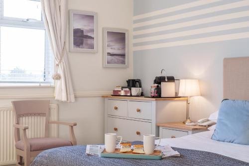 a bedroom with a bed with a tray of food on it at Botany Bay Hotel in Broadstairs