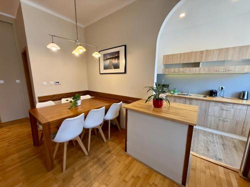a kitchen with a wooden table and white chairs at Pension SKLEP in Prague