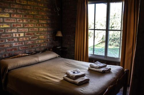 two towels on a bed in a room with a window at Cabañas Buena Vista in Sierra de la Ventana