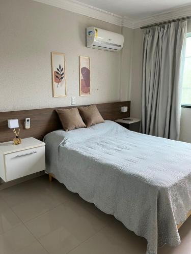 a bedroom with a large bed and a window at Bombinhas Summer Beach Apto moderno a 300 m da praia in Bombinhas
