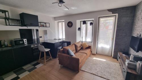 a living room with a couch and a kitchen at T2 avec balcon expo sud en plein centre ville in Évian-les-Bains