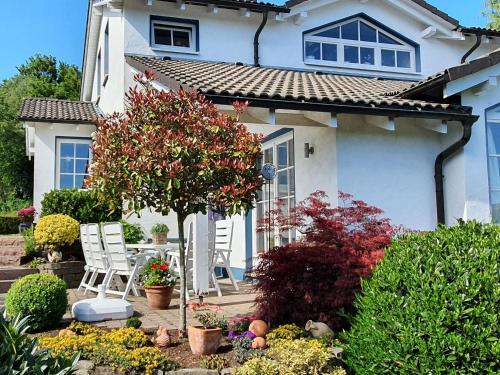 a white house with chairs and flowers in front of it at Schmallenberger Auszeit in Schmallenberg