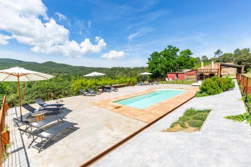 una piscina al aire libre con sillas y sombrilla en MAS TARRÈS, en Madremanya