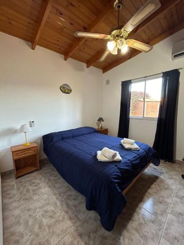 a bedroom with a blue bed and a ceiling fan at Cabañas Buena Vista in Sierra de la Ventana