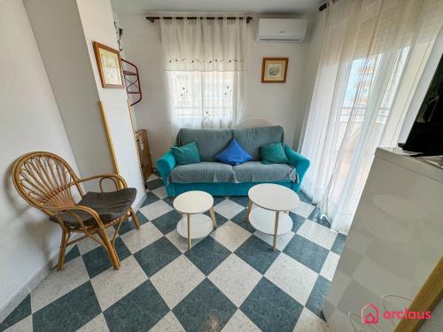 a living room with a blue couch and two tables at La Marina in Oropesa del Mar