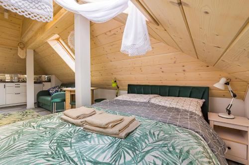 a bedroom with a bed in a wooden attic at Słoneczna Wetlina Apartament 4 Typu Studio in Wetlina
