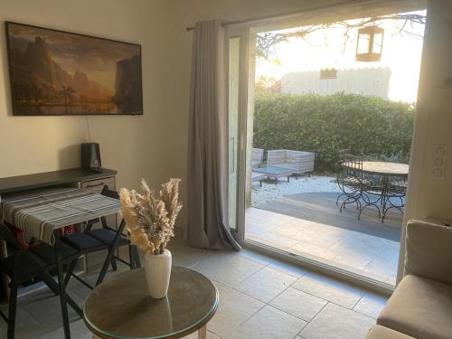 - un salon avec une porte s'ouvrant sur une terrasse dans l'établissement T2 direct sea access with garden, à Calvi