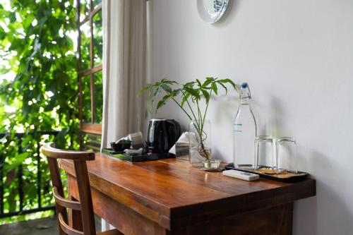 a wooden table with two glasses and a bottle on it at The Fern Cove Villa - Colombo in Battaramulla