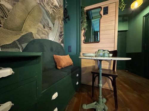 a green room with a table and a green couch at LE JUNGLE-ROOM, Sauna, Hyper-centre in Mâcon