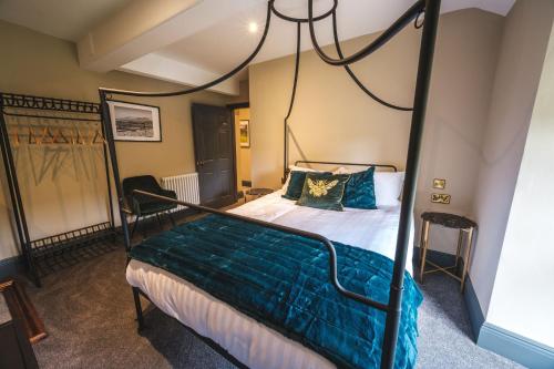 een slaapkamer met een hemelbed met blauwe kussens bij The Richmond Suite in Marske