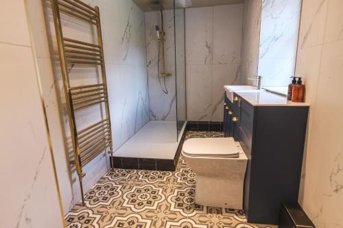 een badkamer met een douche, een toilet en een wastafel bij The Richmond Suite in Marske