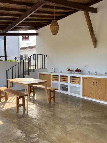 a kitchen with a wooden table and a table and benches at Azóia 10 - Hostel & Casas de Campo in Azoia de Baixo