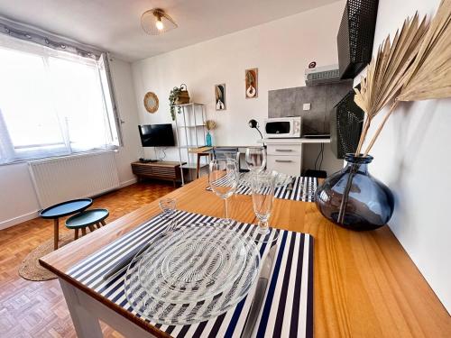 - un salon avec une table et des verres à vin dans l'établissement La suite des 3 piliers studio avec parking privé, à Reims