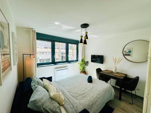 une chambre avec un lit, une table et une fenêtre dans l'établissement Suite Bayah - Check in h24 - Wifi, à Lyon