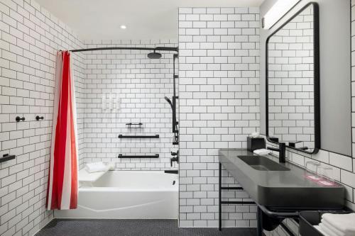 a bathroom with a tub and a sink and a bath tub at Moxy Allentown Downtown in Allentown