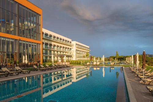 a hotel with a swimming pool in front of a building at Vila Gale Collection Sintra in Sintra