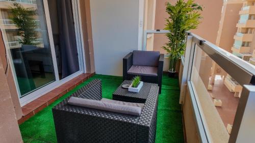 a balcony with a chair and green grass at Apartalux Aqua Marina in La Manga del Mar Menor