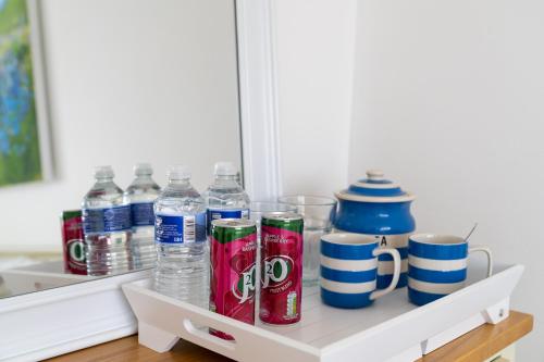 ein Regal mit Wasserflaschen und Bechern darauf in der Unterkunft Trethvor House FREE PARKING Private bathroom Double in Padstow