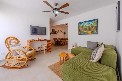 a living room with a green couch and chairs at la maguana - cozy and beautiful 3BR home with pool in Santiago de los Caballeros