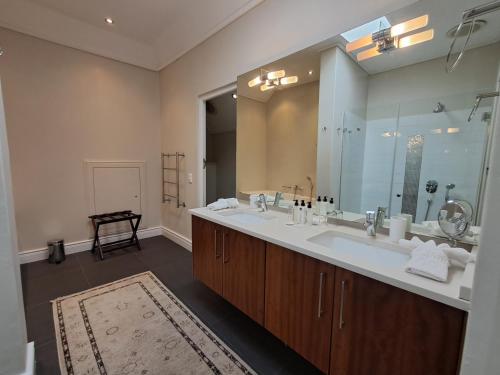 a bathroom with two sinks and a large mirror at Wild Mushroom Country House in Stellenbosch
