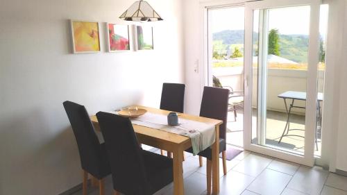 a dining room with a wooden table and black chairs at Appartement In Medenscheid Mit Garten Und Terrasse in Bacharach
