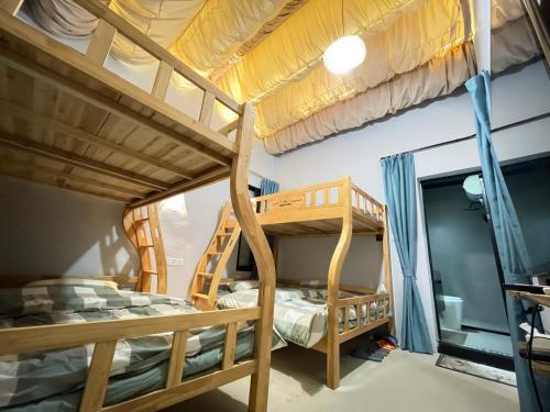 a bunk bed room with two bunk beds at Waiting for the Blossoms B&B Tea House in Shantou