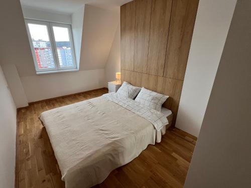a bedroom with a large white bed with a window at Royal Apartments in Skopje