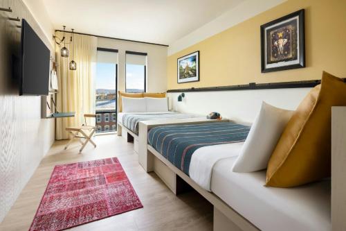 a hotel room with two beds and a television at Moxy Allentown Downtown in Allentown