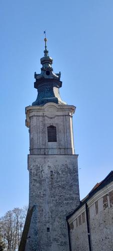 a tall tower with a cross on top of a building at Leśniczówka Zielony Zakątek in Sulejów