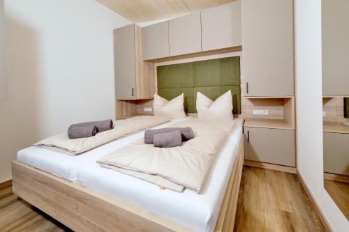 a large white bed with two pillows on it at MTK Tinyhouses in Buxheim