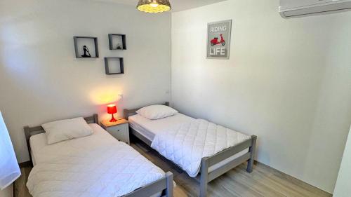 deux lits dans une chambre avec une lampe sur une table dans l'établissement Villa Rico, à Sainte-Maxime