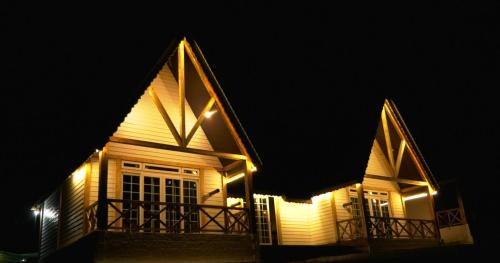 a house with lights on the side of it at night at CEDARS Resorts - Doodhpathri Kashmir in Rengazabal