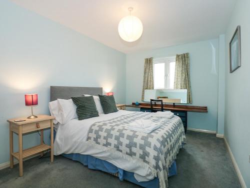 une chambre avec un lit, un bureau et une fenêtre dans l'établissement 1 Oakley Wharf, à Porthmadog