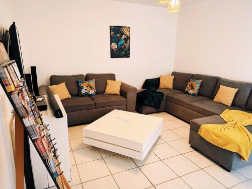 Causses-et-VeyranにあるLa Maison Évasionのソファとコーヒーテーブルのあるリビングルーム