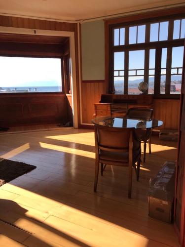 a room with a table and chairs and a piano at La casa Florencia in Puerto Varas