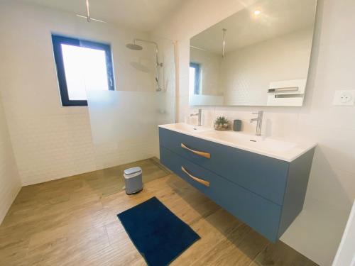 une salle de bain avec un lavabo et un miroir dans l'établissement Fouesnant, superbe maison en bois, proche de la plage de Mousterlin, à Fouesnant