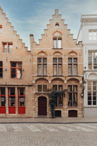a brick building with red doors on a street at Boutique Hotel Malleberg in Bruges