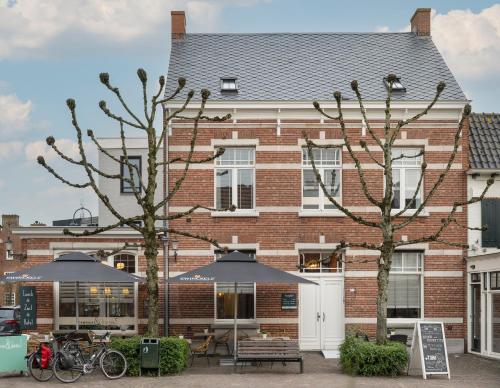 a brick building with umbrellas in front of it at Brownies & downieS Hotel Baarle in Baarle-Nassau