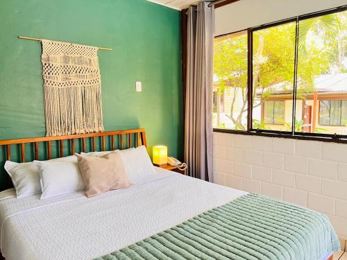 una camera da letto con un letto e una parete verde di CasaBosque a Tarapoto